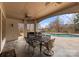 Covered patio with a dining table and seating overlooking a pool and a lake at 706 Eagle Point Ct, Weddington, NC 28104