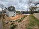 Spacious backyard featuring a patio, creek bed, and wooden fence at 711 E 3Rd Ave, Gastonia, NC 28054