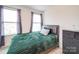 Comfortable bedroom with a green comforter, dark furniture, and natural light at 711 E 3Rd Ave, Gastonia, NC 28054