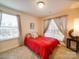Cozy bedroom with a red comforter, carpeted floor, and bright natural light from the windows at 711 E 3Rd Ave, Gastonia, NC 28054