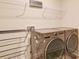 Well-equipped laundry room features modern washer, dryer, shelving and hanging rack at 711 E 3Rd Ave, Gastonia, NC 28054