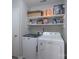 Bright laundry area with washer, dryer, and shelving for ample storage at 7209 Tressel Ln, Mint Hill, NC 28227