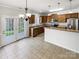 Bright kitchen features wood cabinets, stainless appliances, granite counters, and an adjacent dining area at 111 Charterhouse Ln, Fort Mill, SC 29715