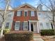 Attractive townhouse with red brick and white siding, set in a community with lush landscaping and a welcoming facade at 111 Charterhouse Ln, Fort Mill, SC 29715