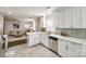 Updated kitchen with white cabinets, stainless steel appliances, and a view to the living room at 119 N Smallwood Pl, Charlotte, NC 28216