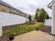 Landscaped backyard with a concrete patio area, white fence, and well-maintained lawn at 120 Snead Rd, Fort Mill, SC 29715