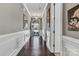 Elegant hallway with hardwood floors, wainscoting, and view of front door at 1284 Independence St, Tega Cay, SC 29708