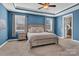 This primary bedroom features blue walls, a decorative ceiling, and large windows at 1284 Independence St, Tega Cay, SC 29708