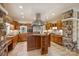 A kitchen featuring granite countertops, stainless steel appliances, custom wood cabinets, and a stone accent wall at 13019 Westmoreland Farm Rd, Davidson, NC 28036