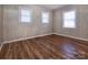 This bedroom is complete with hardwood flooring and three windows for natural light at 132 Kennedy Ave, Kannapolis, NC 28083