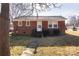 Charming red brick home featuring a cozy entrance with a small porch and manicured bushes at 132 Kennedy Ave, Kannapolis, NC 28083