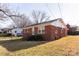 Exterior view of a brick home showcasing its side profile with well-maintained yard and landscaping at 132 Kennedy Ave, Kannapolis, NC 28083