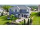 Aerial view of a two-story blue house with a large backyard featuring a patio, firepit and seating at 137 Tenth Green Ct, Statesville, NC 28677