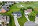 Aerial view of a well-maintained home with a long driveway, surrounded by lush greenery and a nearby golf course at 137 Tenth Green Ct, Statesville, NC 28677