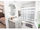 Well-lit bathroom with gray cabinets, granite countertops, and neutral gray and white striped shower curtain at 137 Tenth Green Ct, Statesville, NC 28677