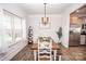 Bright dining room featuring a wooden table, white chairs, wainscoting, and stylish light fixture at 137 Tenth Green Ct, Statesville, NC 28677
