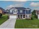 Beautiful home with an attached two-car garage, manicured lawn, and charming front porch decor at 137 Tenth Green Ct, Statesville, NC 28677