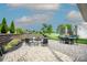 Paver patio with dining and seating area with a retaining wall and lush landscaping at 137 Tenth Green Ct, Statesville, NC 28677