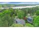 Stunning aerial view of a blue home nestled in lush greenery, near a tranquil lake at 208 Cape August Pl, Belmont, NC 28012