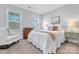 Inviting bedroom features a comfy bed, an accent chair, and natural light from two windows at 208 Cape August Pl, Belmont, NC 28012
