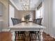 Dining room with a long, white table, black chairs, modern light fixture and decorative vase at 208 Cape August Pl, Belmont, NC 28012