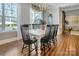Bright dining room with hardwood floors, farmhouse table, modern chandelier, and large windows with beautiful backyard views at 208 Cape August Pl, Belmont, NC 28012