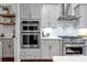 Gourmet kitchen featuring built-in appliances, white cabinetry and quartz countertops at 208 Cape August Pl, Belmont, NC 28012