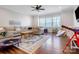 Spacious living room boasts hardwood floors, a ceiling fan, and large windows for ample natural light at 208 Cape August Pl, Belmont, NC 28012