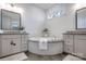 Bright main bathroom featuring double vanities and a luxurious round soaking tub, providing a spa-like experience at 208 Cape August Pl, Belmont, NC 28012