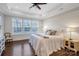 Serene bedroom with shiplap accent wall, trey ceilings, plush bedding, and large windows providing abundant natural light at 208 Cape August Pl, Belmont, NC 28012