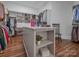 Spacious walk-in closet with custom shelving, storage island, and hardwood floors at 208 Cape August Pl, Belmont, NC 28012