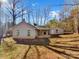 Spacious backyard with a home and detached garage surrounded by trees and a grassy lawn at 215 Creek View Rd, Mooresville, NC 28117