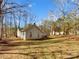 View of the rear exterior showcasing the siding and the spacious yard surrounded by trees at 215 Creek View Rd, Mooresville, NC 28117