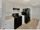 Efficient kitchen featuring white cabinets, black appliances and modern flooring at 215 Creek View Rd, Mooresville, NC 28117