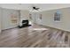 Bright living room featuring modern floors, a ceiling fan, a fireplace and multiple windows at 215 Creek View Rd, Mooresville, NC 28117