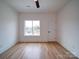 Bright bedroom with hardwood floors, a ceiling fan, and a large window overlooking greenery at 2511 Dundeen St, Charlotte, NC 28216
