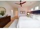 Bright bedroom features a ceiling fan, wood floors, and a dark wood dresser with decorative mirror at 2511 Dundeen St, Charlotte, NC 28216