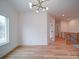 Bright, spacious empty room with modern light fixture and wood floors at 2511 Dundeen St, Charlotte, NC 28216