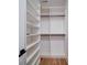 Organized walk-in closet with white shelving units and wood floor at 2511 Dundeen St, Charlotte, NC 28216