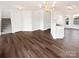 Open-concept living area featuring wood flooring, a chandelier, stairs, and natural light at 3161 Glen Robin Ct, Charlotte, NC 28205