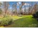 Backyard features lush green lawn, mature trees, and privacy fence at 3536 Wylie Meadow Ln, Charlotte, NC 28269