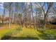 Backyard with lush lawn, mature trees, and a wooden fence at 3536 Wylie Meadow Ln, Charlotte, NC 28269