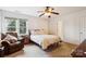 Inviting bedroom with window view, ceiling fan, and comfortable sitting area at 3536 Wylie Meadow Ln, Charlotte, NC 28269