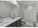 Bright bathroom featuring double sinks, modern fixtures, and a shower-tub combination with a neutral color palette at 4159 Millstream Rd, Denver, NC 28037