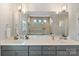 Modern bathroom with double vanity, sleek gray cabinetry, large mirror, pendant lights and tiled shower at 4159 Millstream Rd, Denver, NC 28037