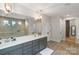 Modern bathroom with double vanity, sleek gray cabinetry, large mirror, pendant lights and tiled shower at 4159 Millstream Rd, Denver, NC 28037