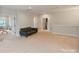Spacious bonus room with neutral carpeting and a futon sofa, offering versatile living space at 4159 Millstream Rd, Denver, NC 28037