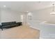 Open bonus room with a gray futon sofa, neutral walls, and carpet at 4159 Millstream Rd, Denver, NC 28037