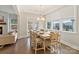 Bright dining room features a white table, seating for eight, and large windows overlooking the outdoor scenery at 4159 Millstream Rd, Denver, NC 28037