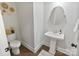 Charming half bathroom features pedestal sink, decorative wall art, and wood-look flooring at 4159 Millstream Rd, Denver, NC 28037